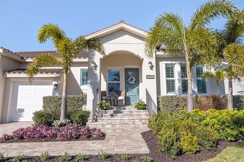 Chic coastal style and new landscaping with flowering perennials and tropical plantings create tons of curb appeal.