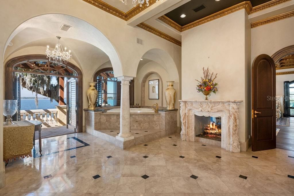 Primary Bathroom with terrace access and double-sided carved marble fireplace.