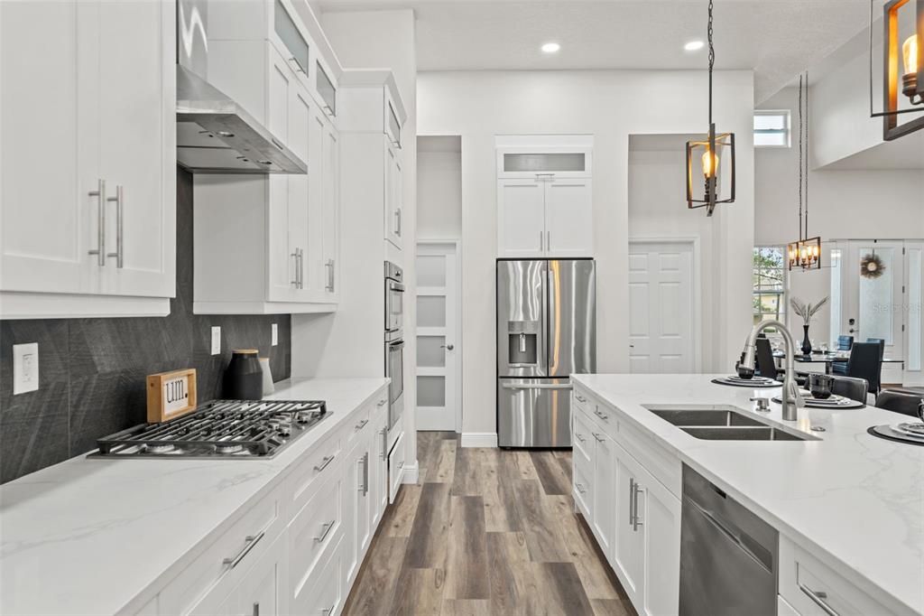 Kitchen featuring gas cooktop with range hood and built in microwave and oven.