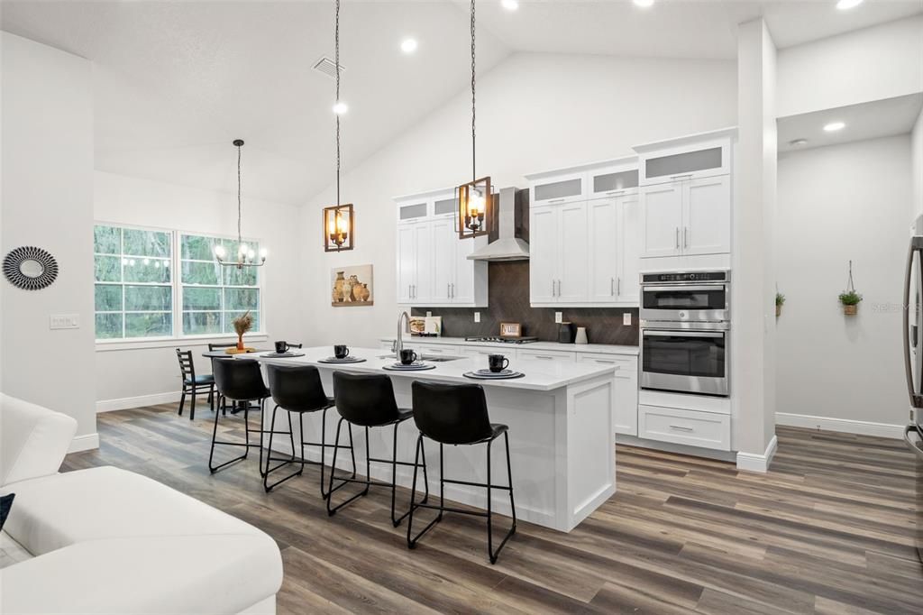 Chefs Kitchen with modern backsplash, light fixtures and quarts counters.