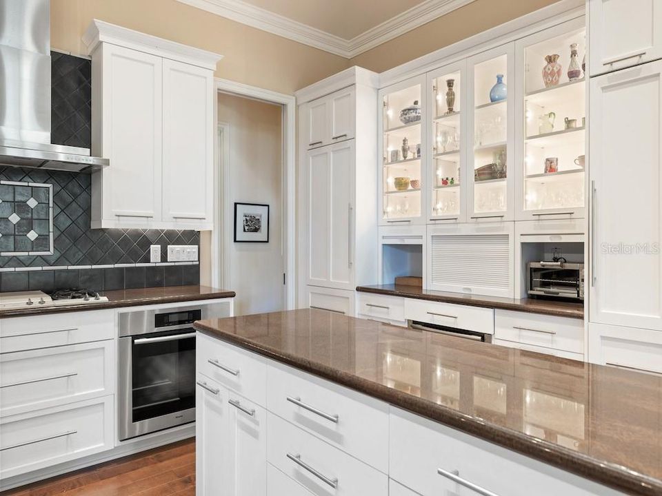 Large Prep Island with custom white cabinetry and large hidden walk-in pantry.