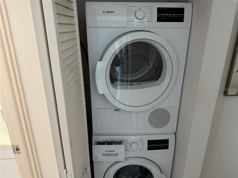 Stacked BOSCH washer and dryer located next to guest bathroom.