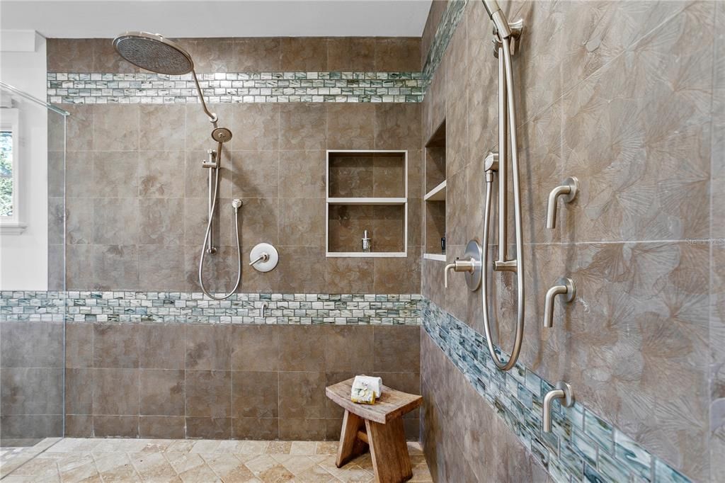 The updated primary bathroom has a large shower with 2 shower heads and 2 sprayers.