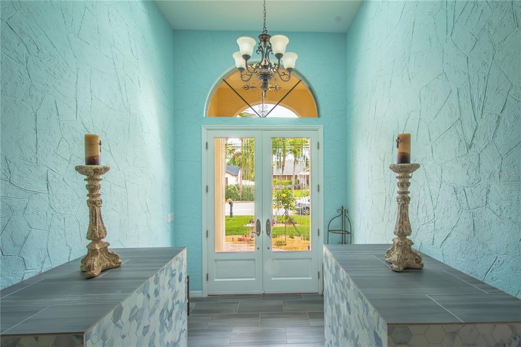 Glass French doors open to a spacious foyer.