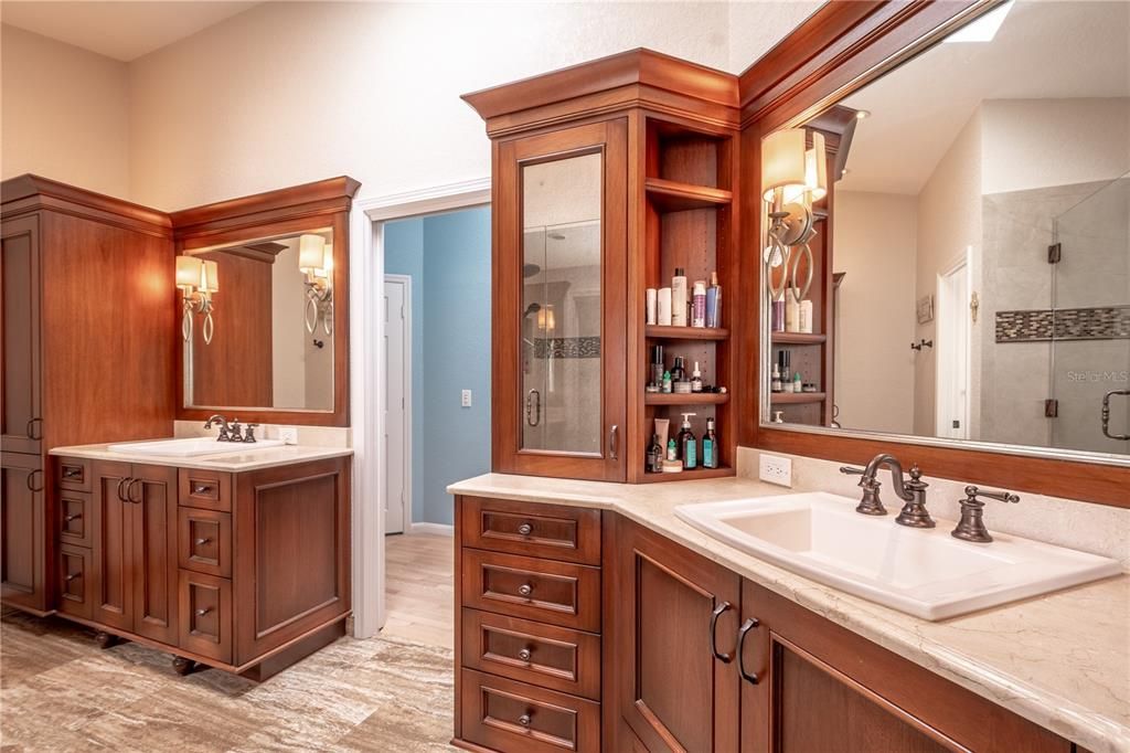 His Anne her vanities feature stone countertops and light sconces.