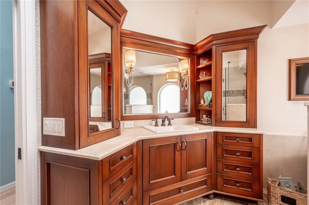The en-suite bath features his and hers mirrored vanities in wood cabinetry.