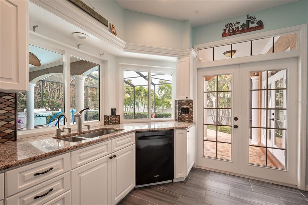 The kitchen features French doors to the lanai and pass through windows the the outside counter.