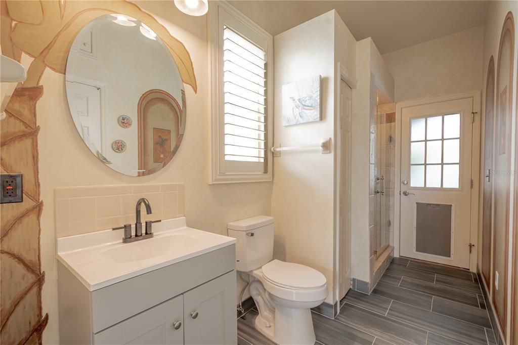 The pool bath features a mirrored vanity with storage and down light fixture, and a walk in shower.