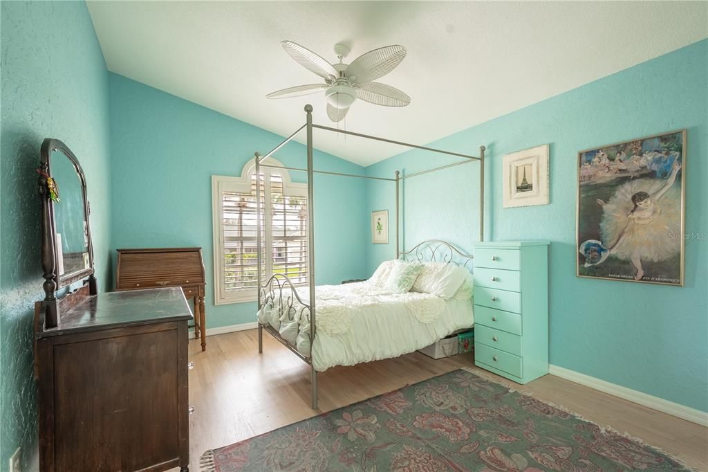 Bedroom 4 features high ceilings with ceiling fan, a built in closet, wood floor and plantation shutters.