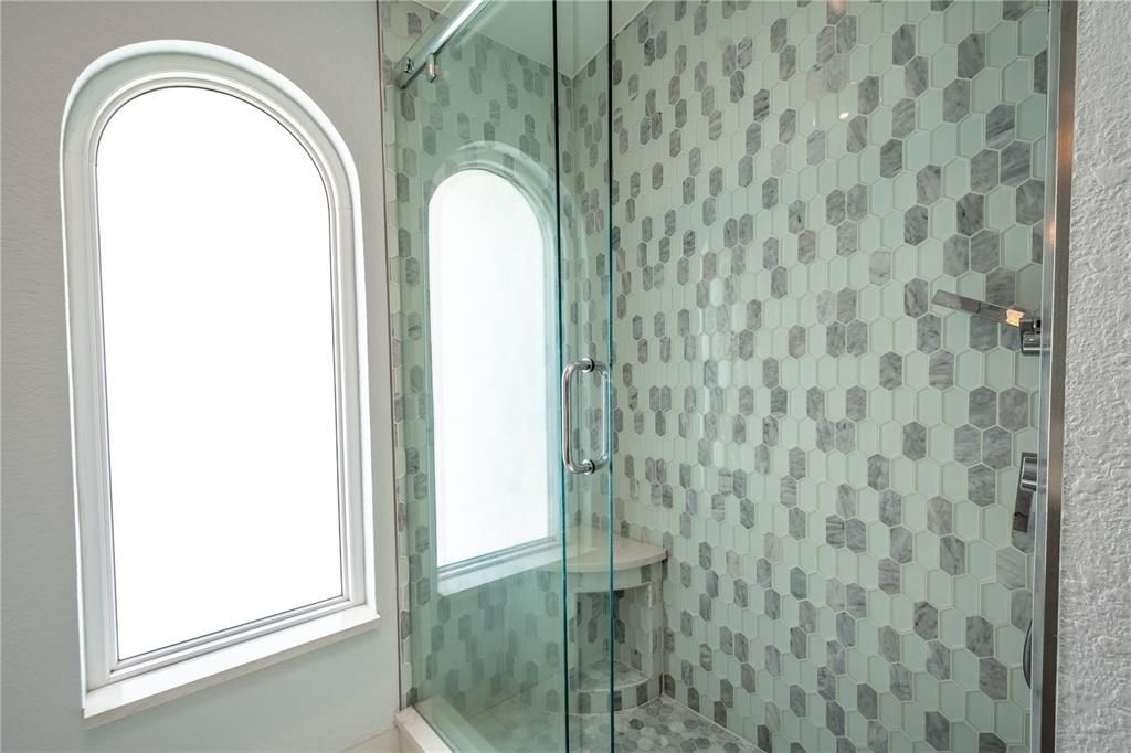 The 3rd bath features a beautifully tiled walk in shower with built in bench.