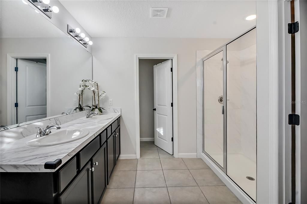 The en suite Master bath offers a Raised Double Vanity, Shower enclosure, private Water Closet, Ceramic Tile Flooring and access to the HUGE clothes closet!