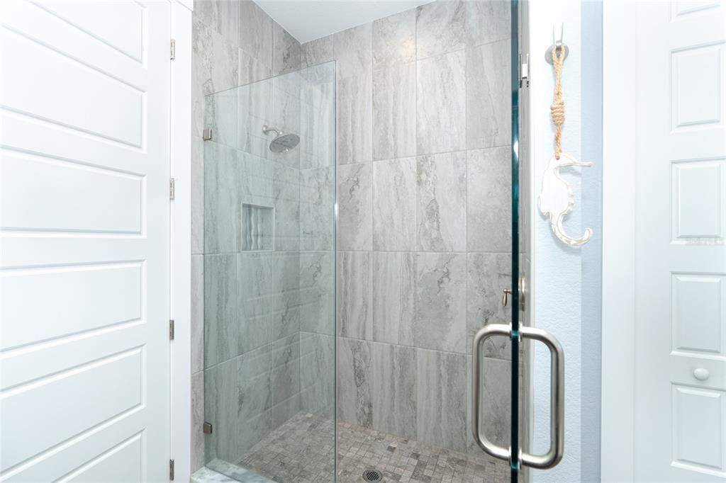 Bath #2 has a glass enclosed shower with floor to ceiling decorative tile