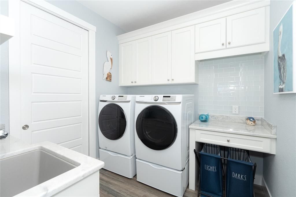 Utility Room has additional cabinetry for storage as well as a utility sink & closet