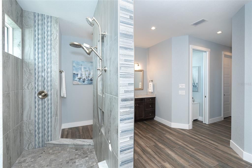 Master shower is highlighted with floor to ceiling decorative tile