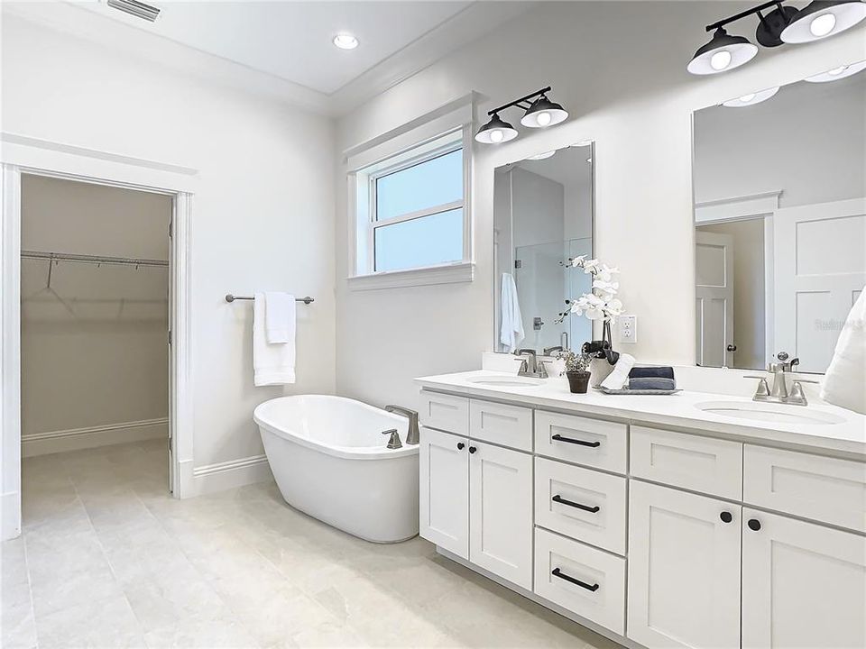 Owner's bath with stand alone tub, walk in shower and double vanity and plenty of natural light as well as large walk in closet.