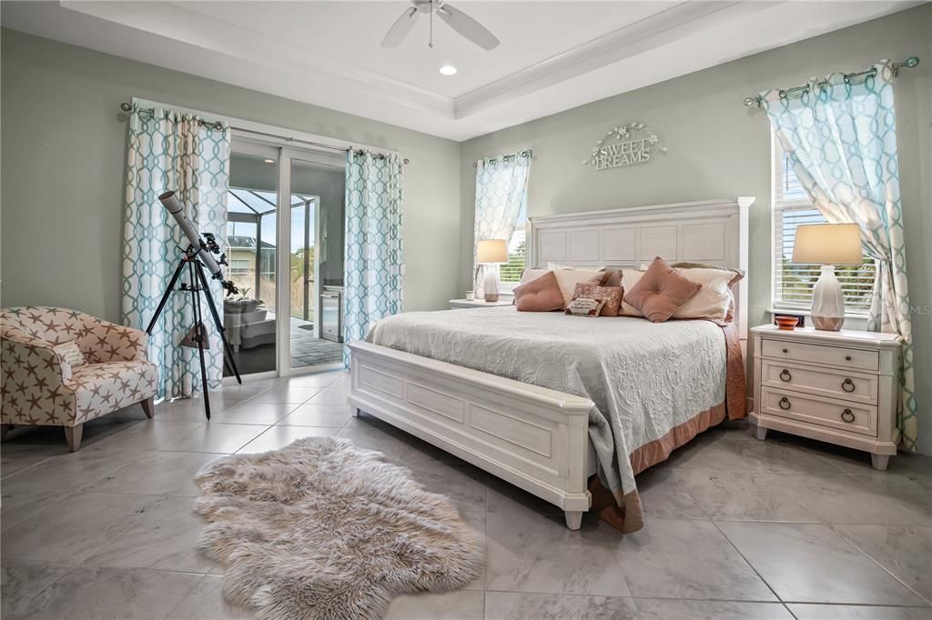 THE PRIMARY BEDROOM HAS DECORATIVE TRAY CEILING WITH RECESSED LIGHTING. STEP THROUGH THE SLIDER DOOR AND ENJOY YOUR MORNING ON COVERED LANAI