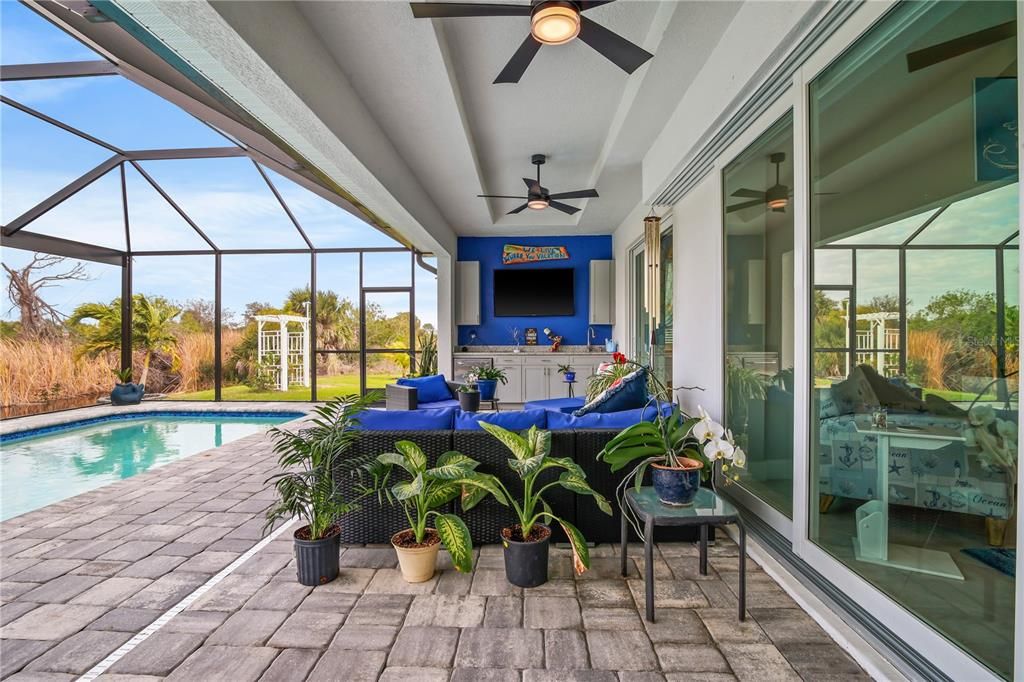 THE COVERED LANAI FEATURES AN OUTDOOR KITCHEN AREA