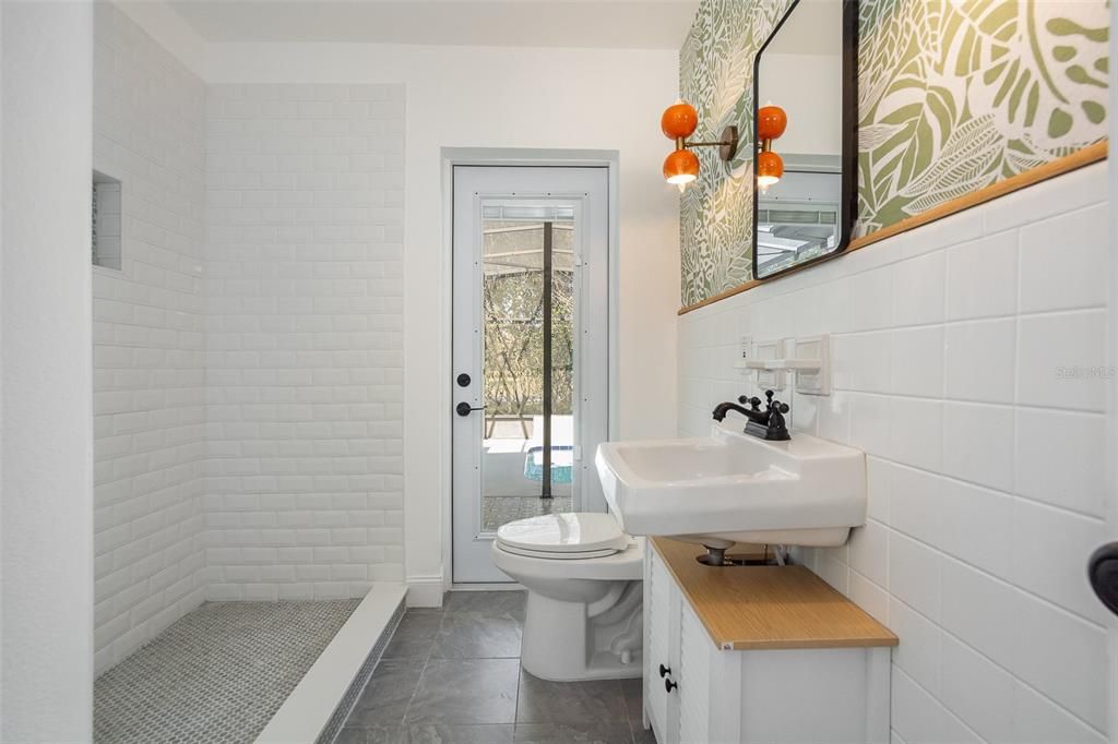 Guest bathroom with French door leading to pool