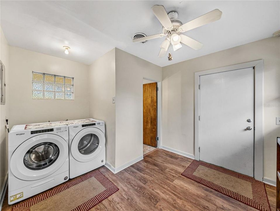 Inside laundry room....washer and dryer will remain.  White door leads to the garage.  Small wood door is the entrance to the half bath.