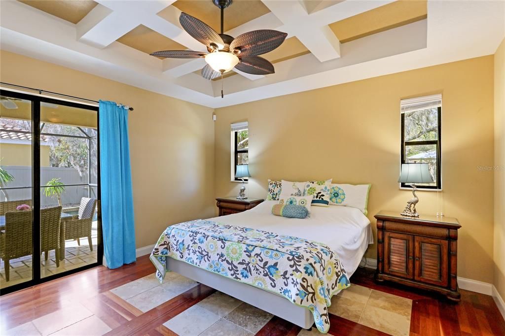 Primary Bedroom with sliders to the Lanai overlooking the Salt Water Pool and Spa.