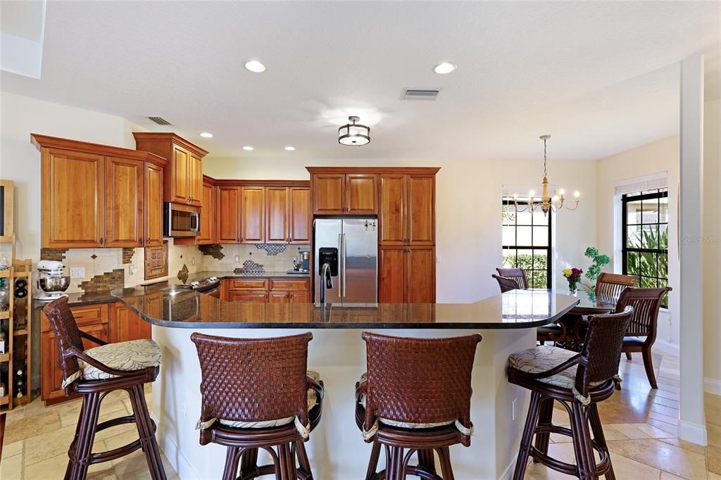 Custom Cabinetry with Crown Moldings and  built in Refrigerator, Granite countertops and custom tile backsplash crown