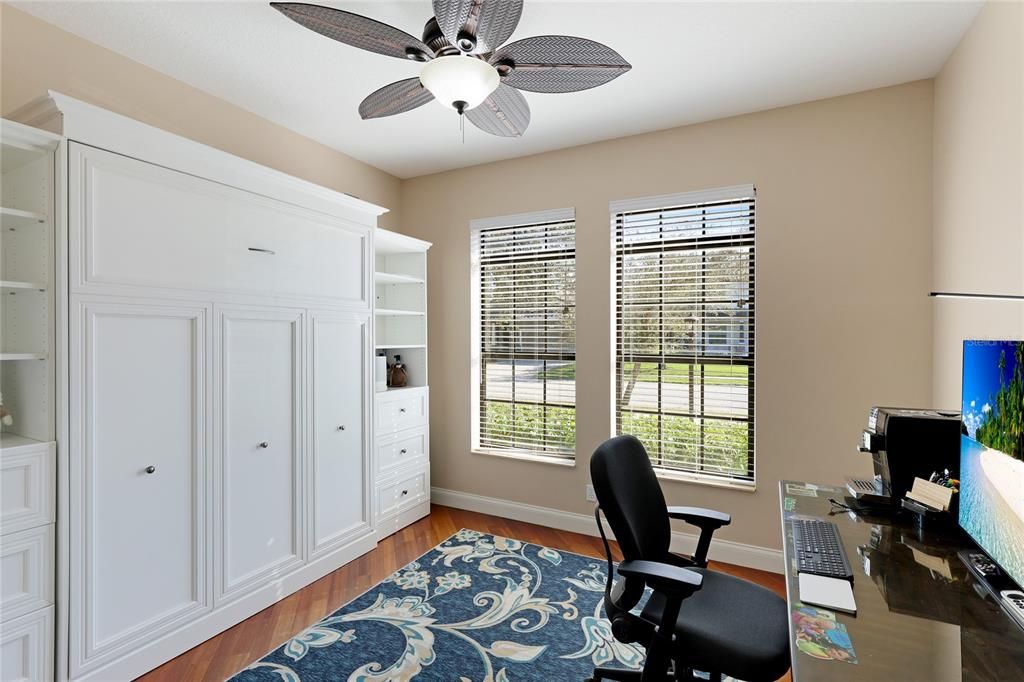 Bedroom 3 with hardwood floors, 2 large windows with abundant light and a Queen size built-in Muuphy style bed with side built-in shelving.