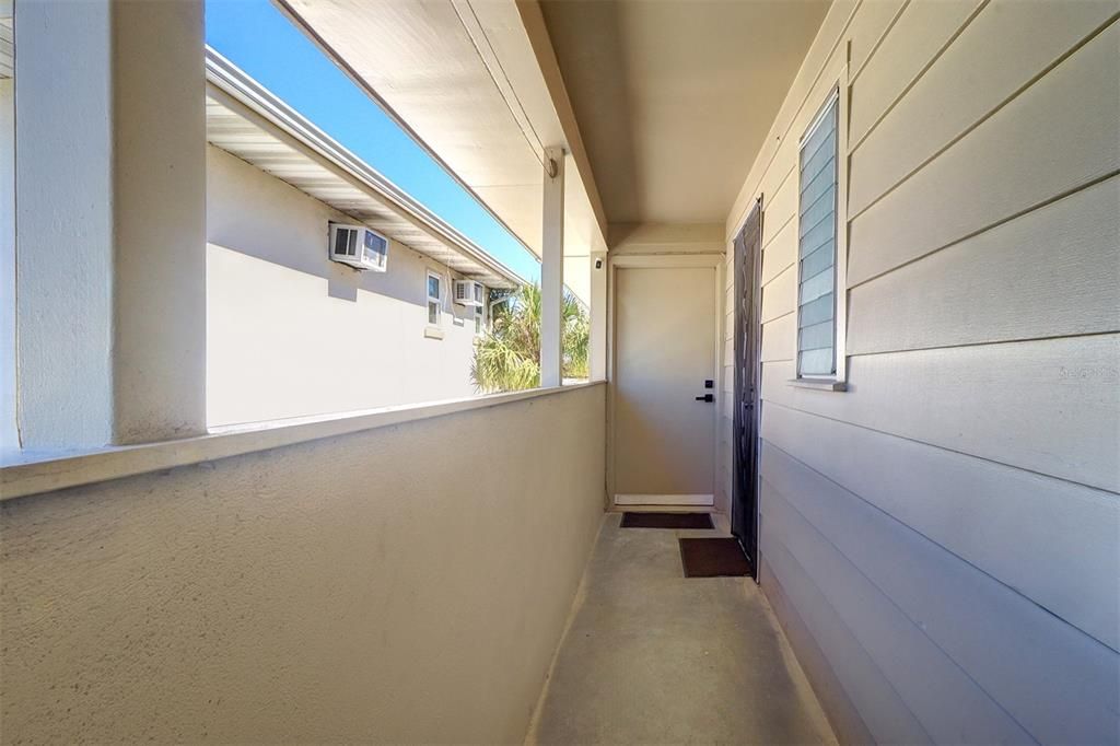 View of the back door of Unit 2 and the hallway before proceeding down the stairs to the backyard