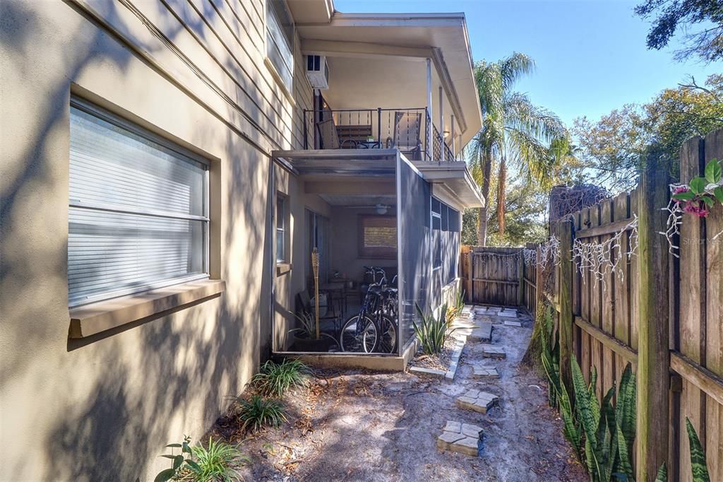 View along the south side of the triplex showing Unit 1 screened porch with side and rear access to yard