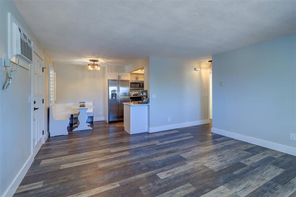 View from the living area into the banquette dining seating area and a glimpse of the kitchen of Unit 2