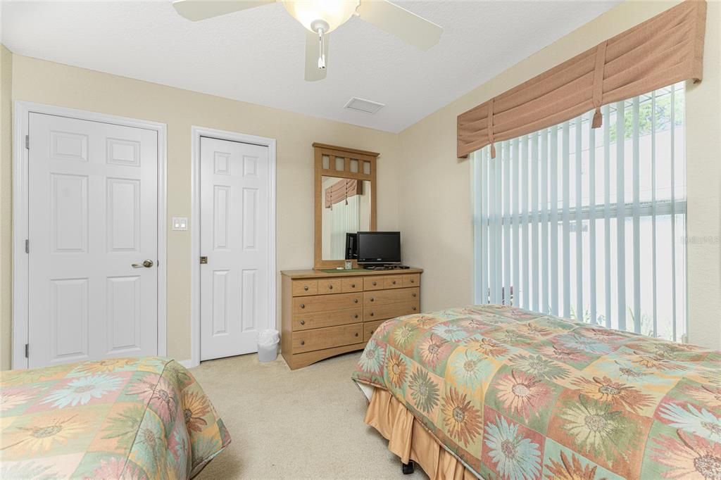 Bedroom #3 has carpeted flooring, a walk in closet and a ceiling fan.