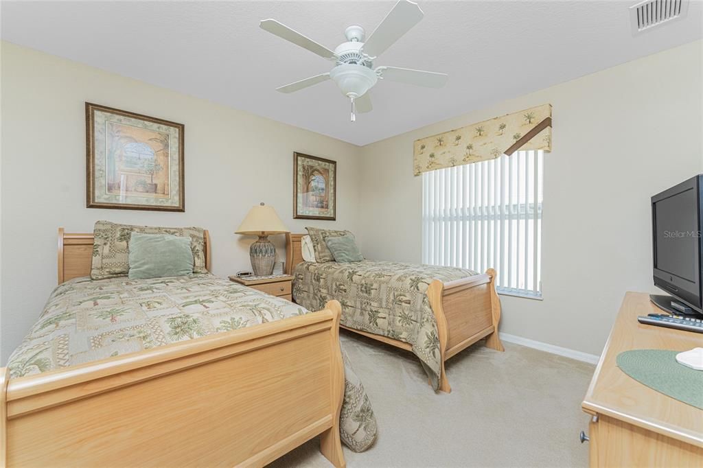 Bedroom #2 is a spacious room with carpeted flooring and a ceiling fan.