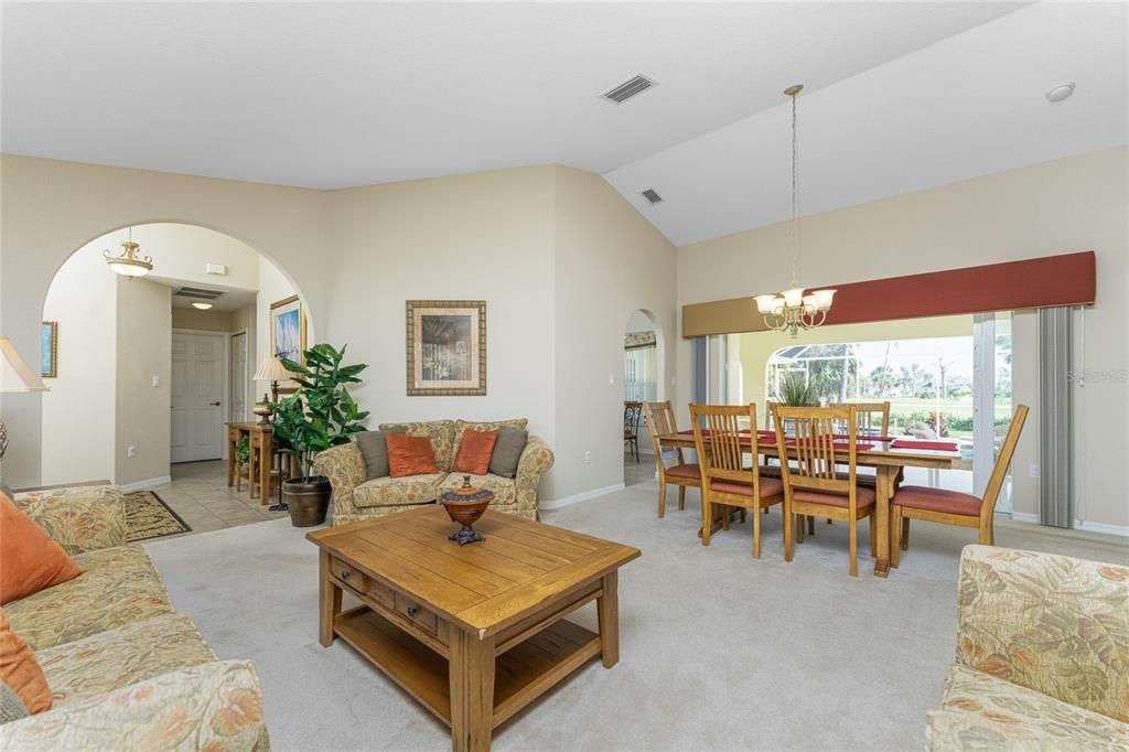 The living room and dining room have carpeted flooring and a chandelier over the dining area.