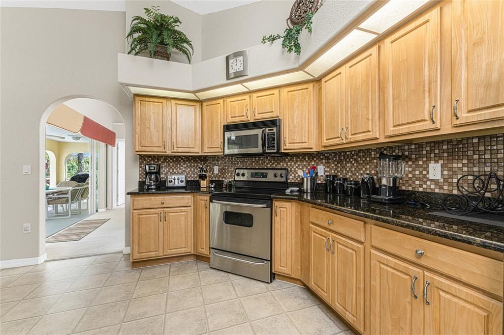 The kitchen has built in plant shelves, and a tiled backsplash.