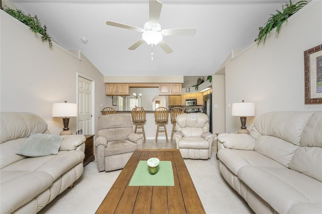 The family room also has carpeted flooring, a ceiling fan and built in plant shelves on either side of the room.