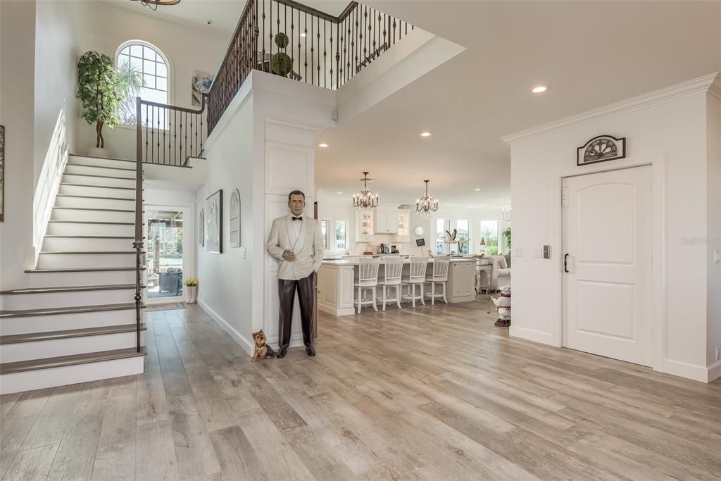 Beautiful view of the grand staircase leading into the kitchen and family room