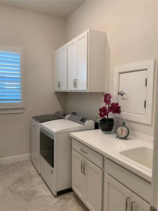 Nice sized laundry room with sink and cabinets