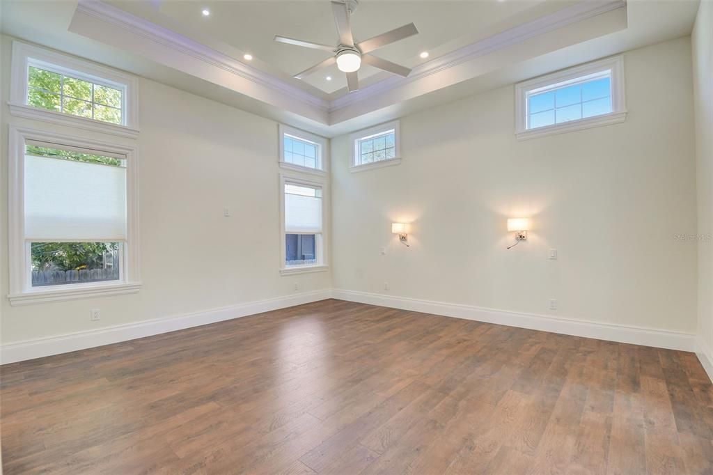 Spacious Master Bedroom with Coffered Ceilings inset with led mood setting lighting, and built-in bedside lighting.