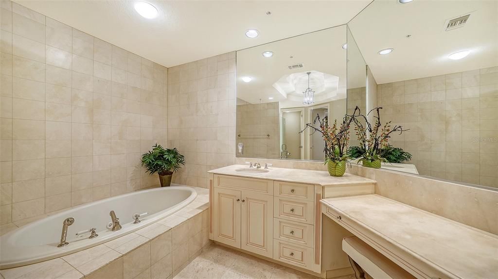 Separate vanities and large tub in master bathroom.