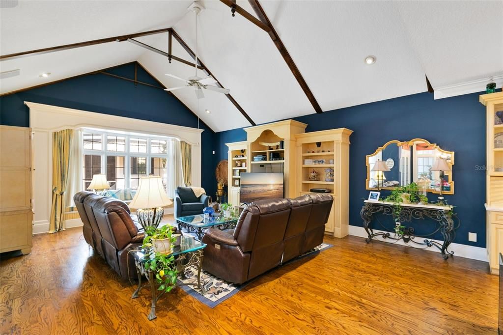 Vaulted ceilings and a window seat overlooking the pool create a bright and inviting space, complemented by French doors that provide seamless outdoor access.