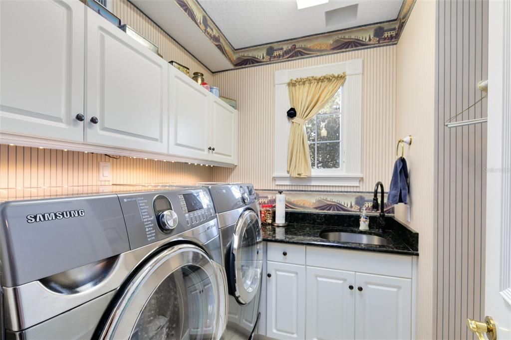 Your laundry room includes a sink and cabinet space.