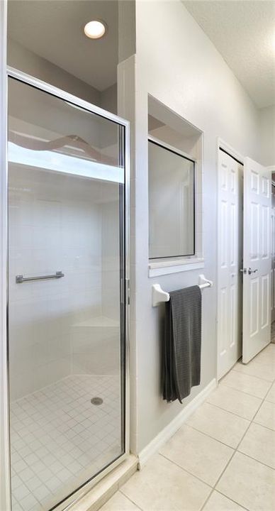 large shower enclosure and linen closet