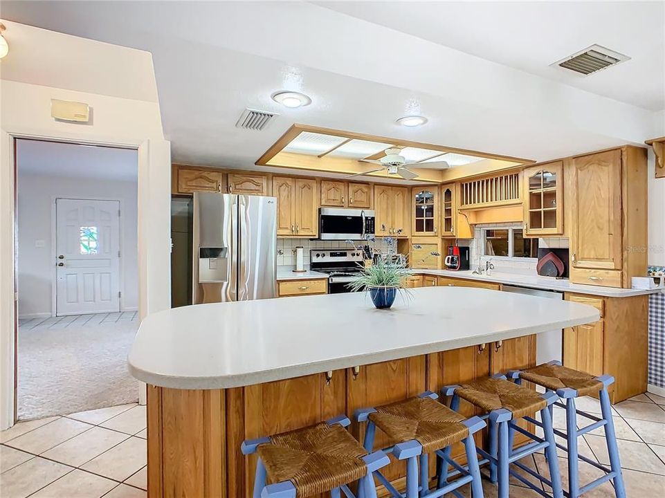 The kitchen is spacious and has been remodeled with a center island/breakfast bar, an abundance of counter space with corian counter tops, wood cabinets and stainless-steel appliances.