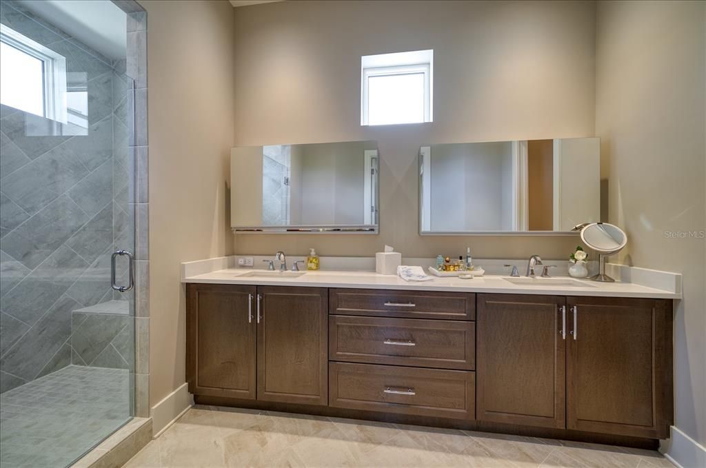 Primary bath area with large walk in shower, double vanities and quartz countertop.