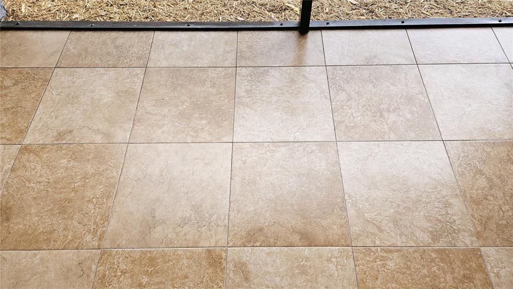 Zero grout line matching tile flows out to the screened in porch.