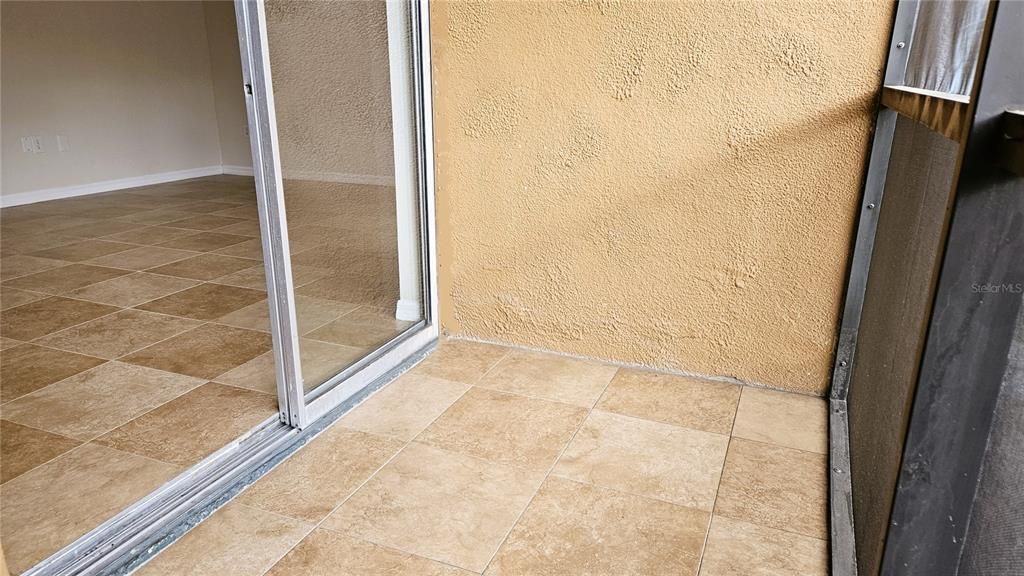 Zero grout line matching tile flows out to the screened in porch.