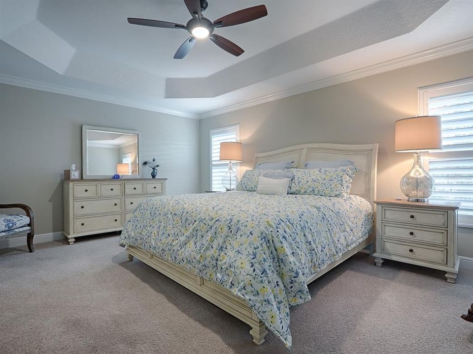 PRIMARY BEDROOM WITH TRAY CEILING, UPGRADED CEILING FAN WHICH YOU WILL FIND THROUGHOUT THE HOME.