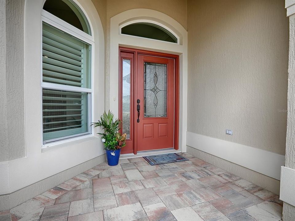 LOVELY ENTRANCE WITH LEADED GLASS FRONT DOOR, SIDELITE, AND TRANSOM.