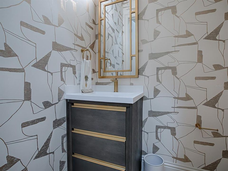 Powder room updated with custom fixtures and wallpaper.