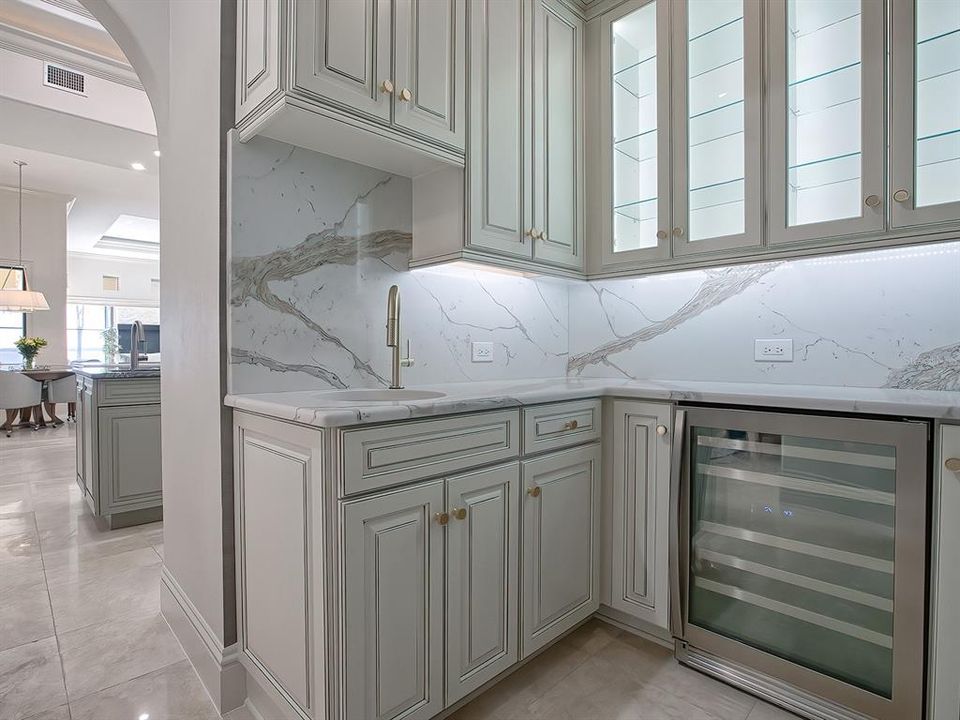 The butler's pantry was created to provide a wet bar, wine refrigerator, and beautiful custom cabinetry with glass doors and interior lighting.