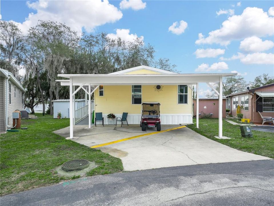 The driveway is wide enough for two cars and is fully covered by the carport.